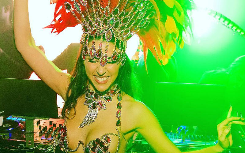 A woman wearing a feathry headdress and jewelled bikini 