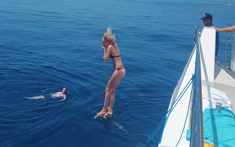A girl jumping off a boat into the sea