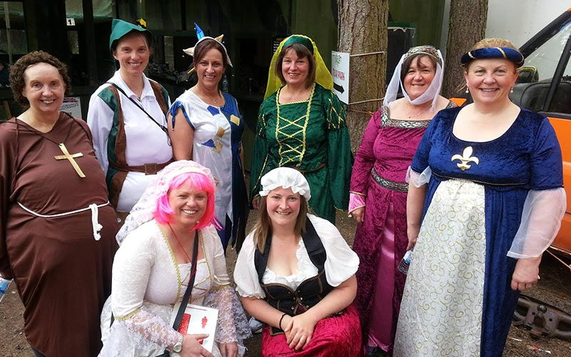 Eight women in Sherwood Forest themed fancy dress outfits