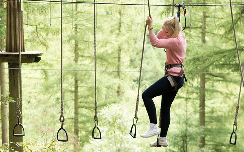 A girl in a harness on some high ropes