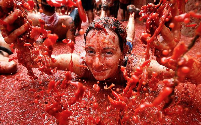 A girl covered in tomatoes at La Tomatina festival