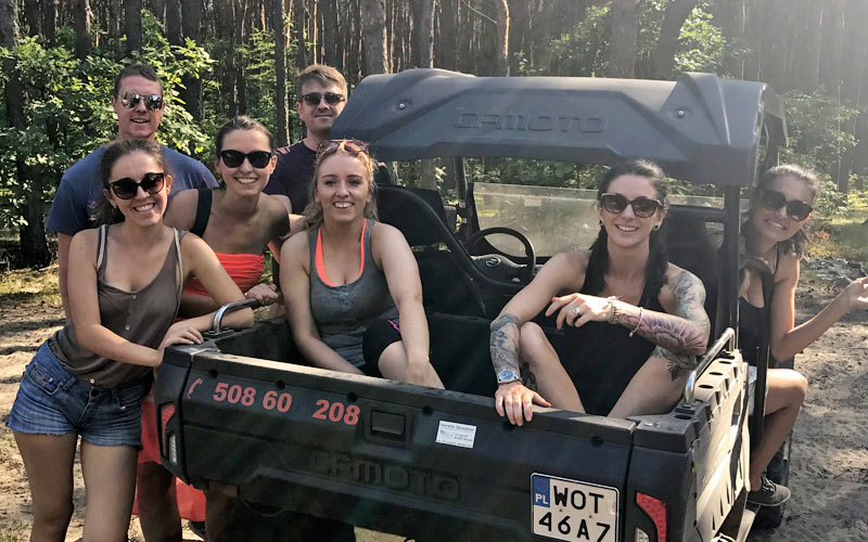 A group of people sat in and around a 4x4 vehicle