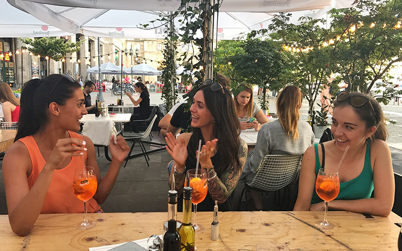 Three women sitting at a table drinking and smiling