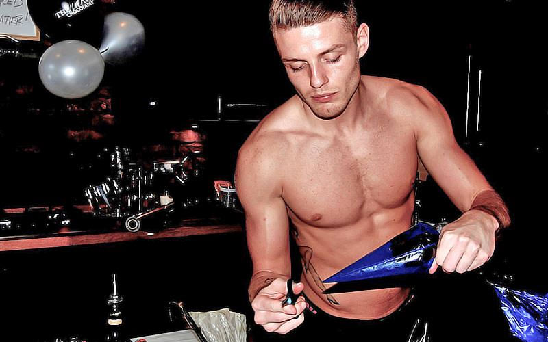 A topless man holding a pipe