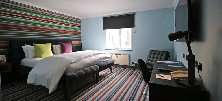 A colourful hotel room with a large bed