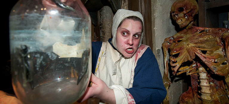 A plague doctor holding a jar