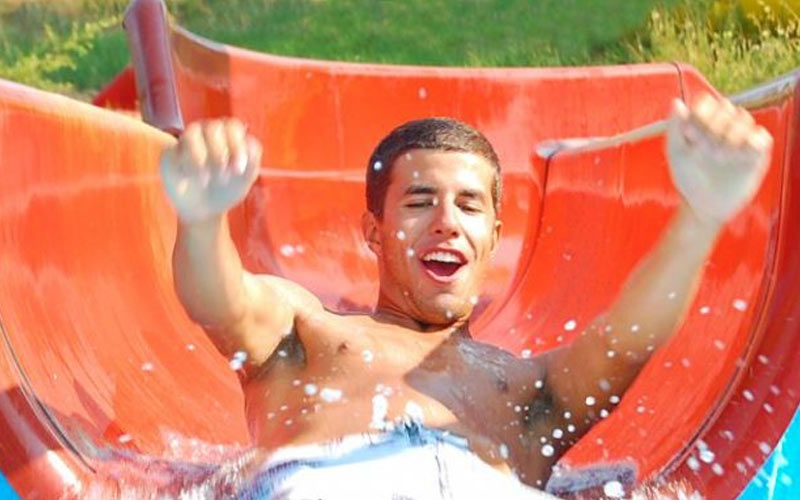A man sliding down an orange water slide