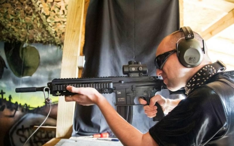 A man firing a gun at a shooting range
