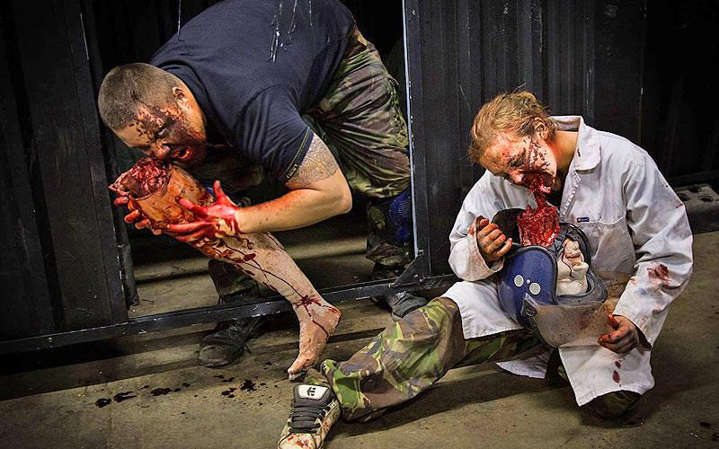 Two people pretending to be zombies and eating body parts