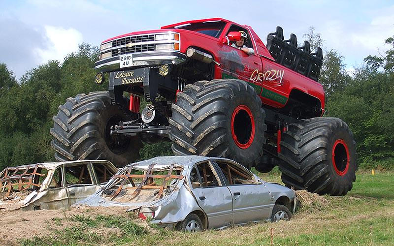 A monster truck crushing two cars