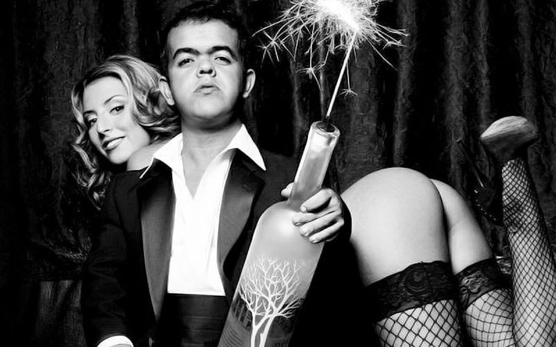 A stripper with her bum in the air and a midget in front of her