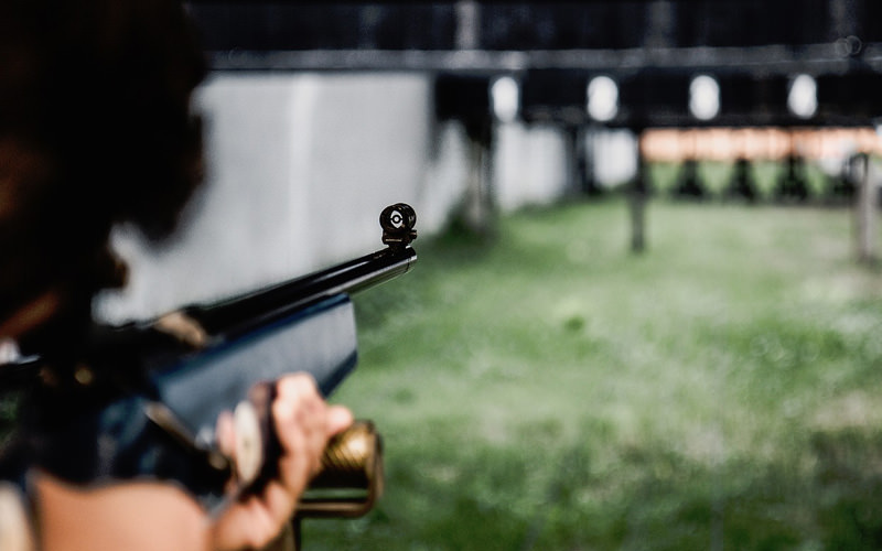A man firing a gun in a shooting range