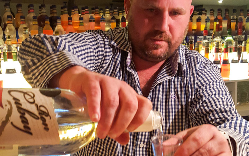 A man pouring a shot into a shot glass