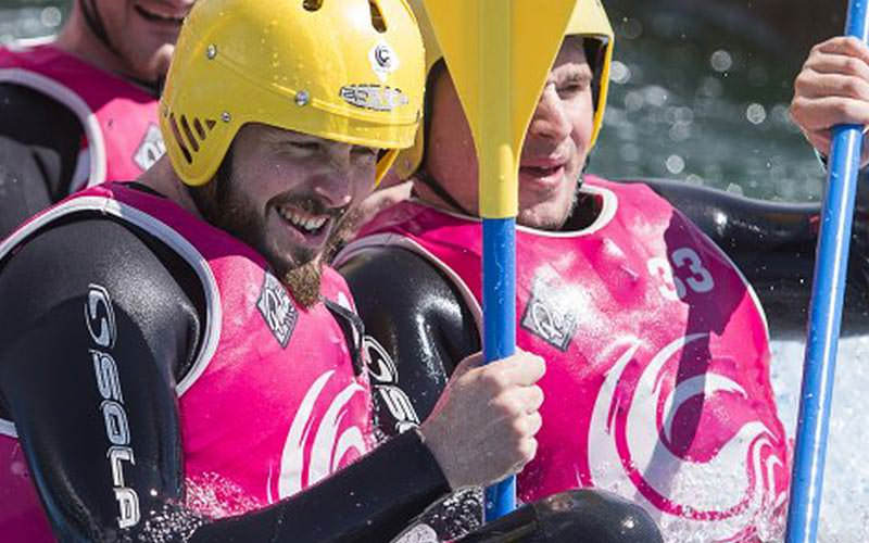 Some men padding a boat in white water rapids