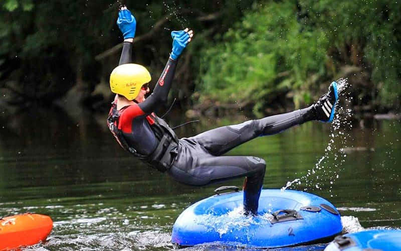 A man falling back from a rubber ring, into the water