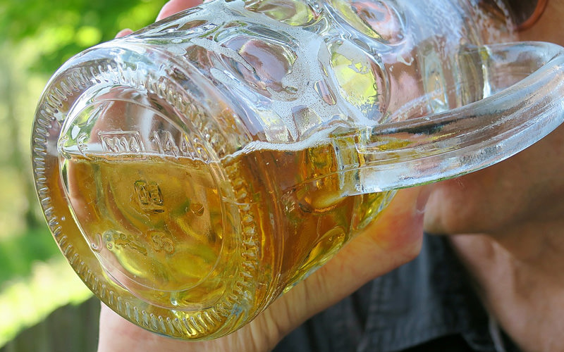 A man drinking a stein of beer