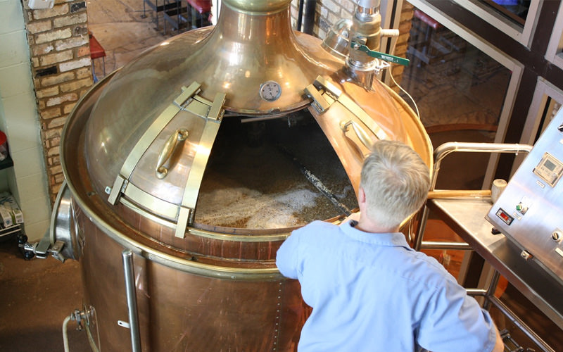 A man tending to a keg in a brewery