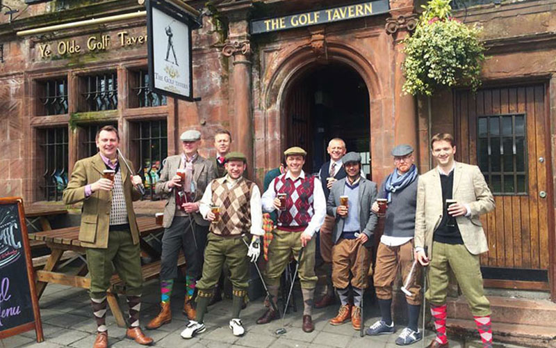 A group of men outside a pub in Edinburgh, dressed for pub golf