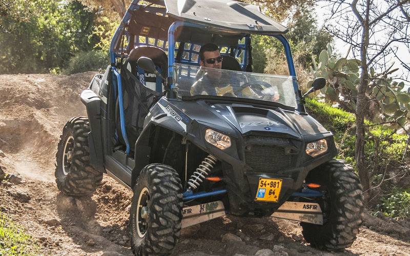 A man driving a rage buggy down hill