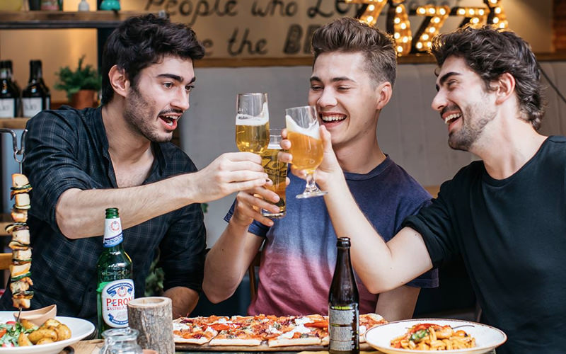 Four men clinking their pints together in Harrogate
