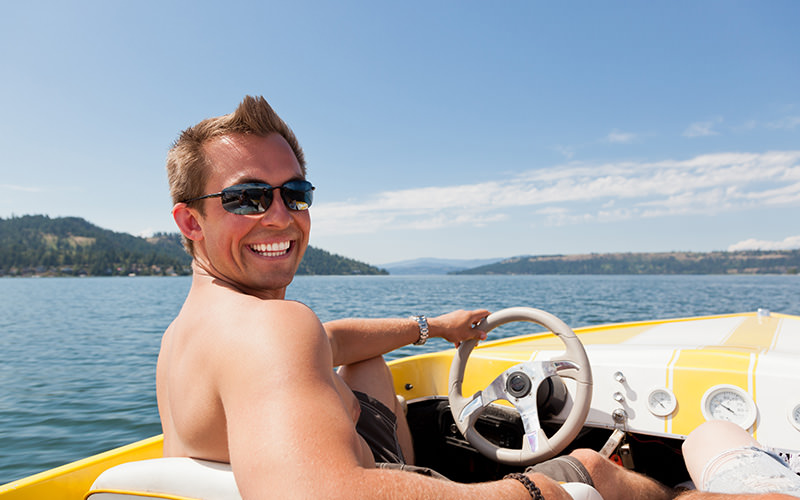 A man driving a speed boat on the sea