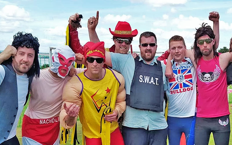 Seven men dressed up in wrestlers outfits on a stag do