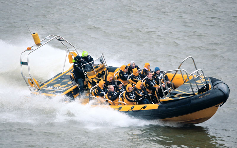 Some men on a speed boat down the Thames