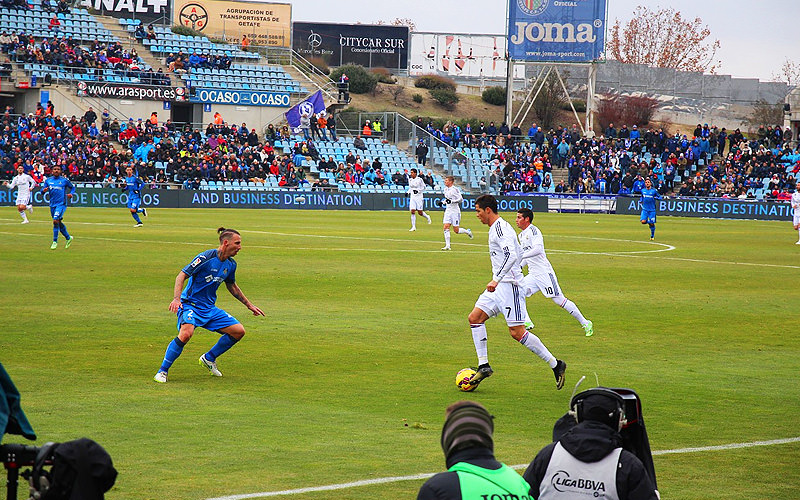 People playing football on an outdoor pitch