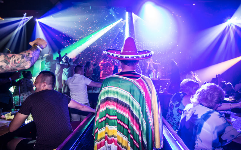 A man heading into a club, wearing a sombrero 