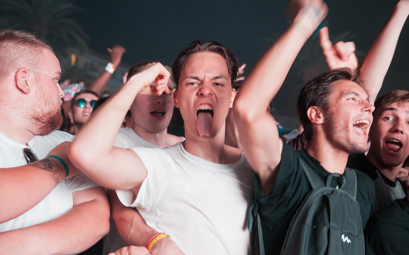 A group of men partying, one with his tongue out