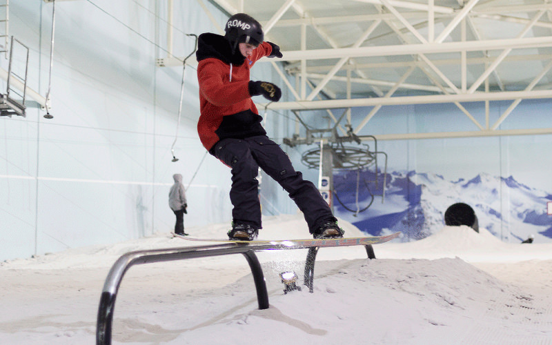 A man snowboarding indoors