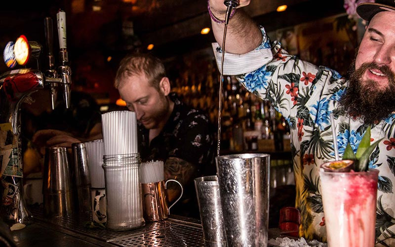 A barman pouring a shot from a height