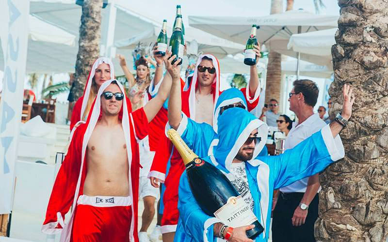 Some stags wearing boxing robes and holding bottles of Champagne
