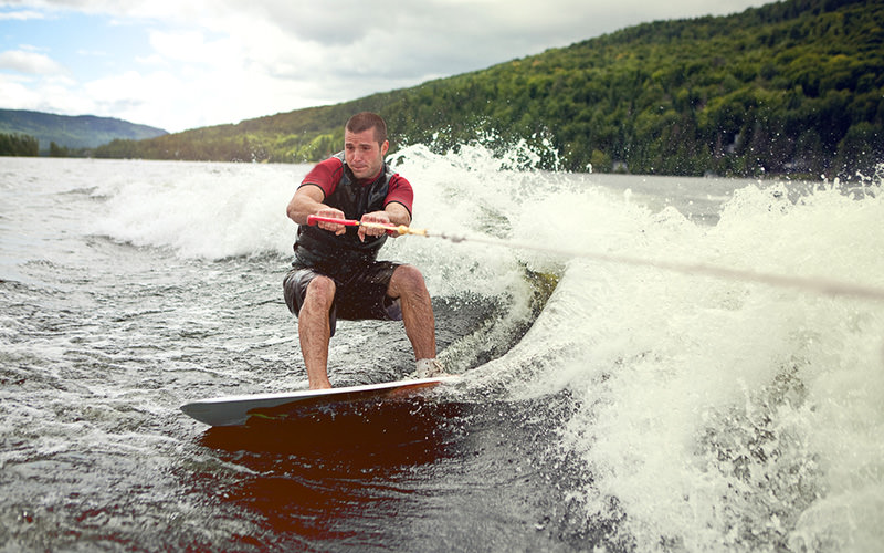 A man on a surf board in the sea, being pulled along 