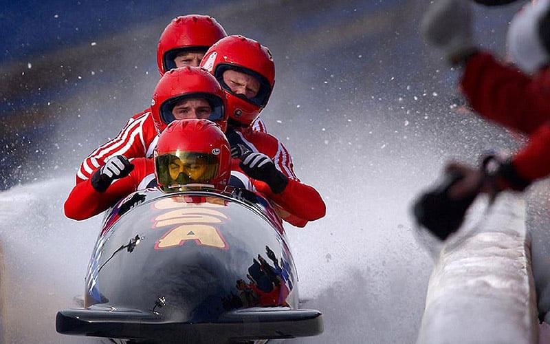 Some men on a bobsleigh in the snow