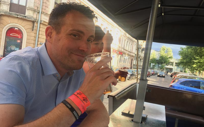  A man drinking a beer on a beer bike