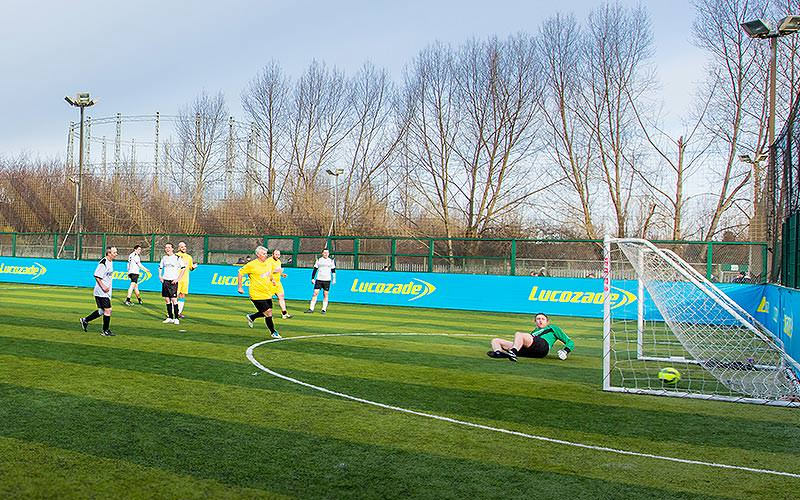 A group of people playing football on a pitch