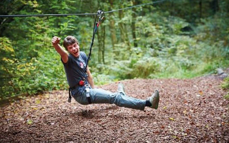 A man attached to a rope with his fist in the air