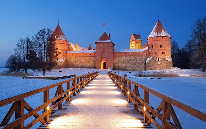 A bridge leading to a castle, with snow on the ground