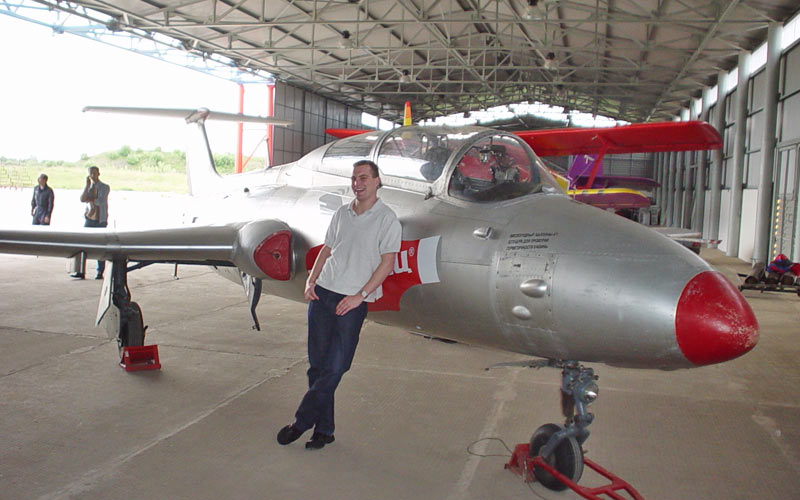 A man leaning on an aircraft in a hanger