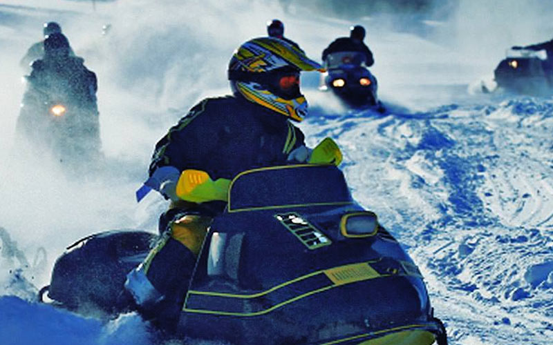 A group of people on snowmobiles