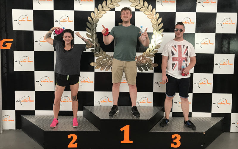 Three people on first, second and third podiums, celebrating