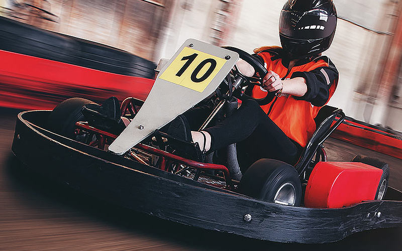 Someone riding a go kart indoors
