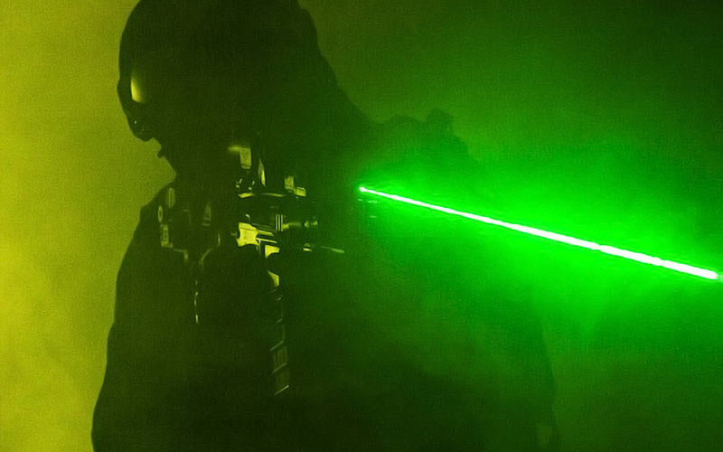 Someone pointing a laser gun with a green laser beam coming out of it