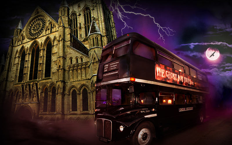 A bus with a ghost tour banner on it and a cathedral in the background