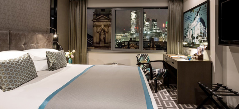 A hotel room in London with views over the city at night