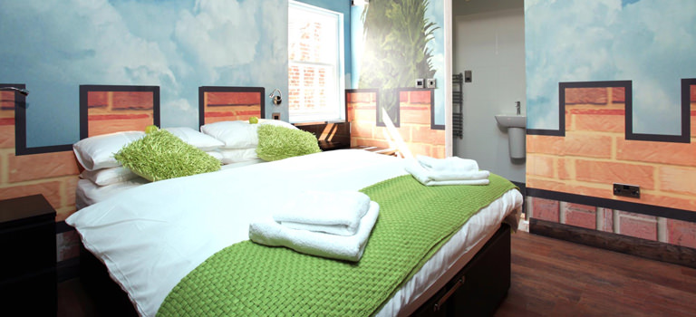 A colourful room with cloud wallpaper and grass covered cushions