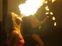 A woman blowing fire in a bar