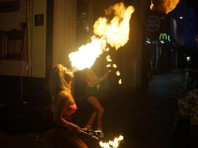 A woman blowing fire in a bar
