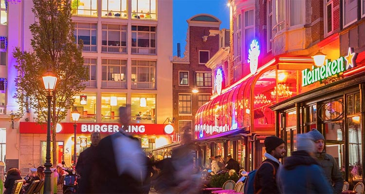 A nighttime shot of the exterior of some bars in Leidseplein